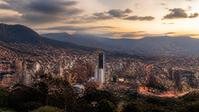 Ciudad latinoamericana al atardecer con montañas al fondo